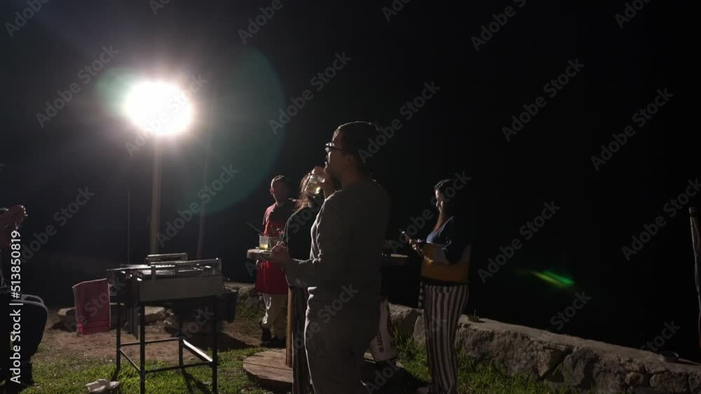 male and female friends eating barbecue and having drinks outdoors in a country house in the highlands on the grass at night in 4k male and female friends eating barbecue and having drinks outdoors in a country house in the highlands on the grass at night in 4k