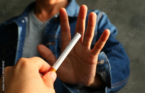 Man refuses to smoke when his friend hands him a cigarette under the concept of stopping smoking that destroys health