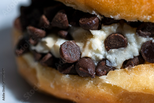 Close up of a Cream-filled doughnut with chocolate chips 