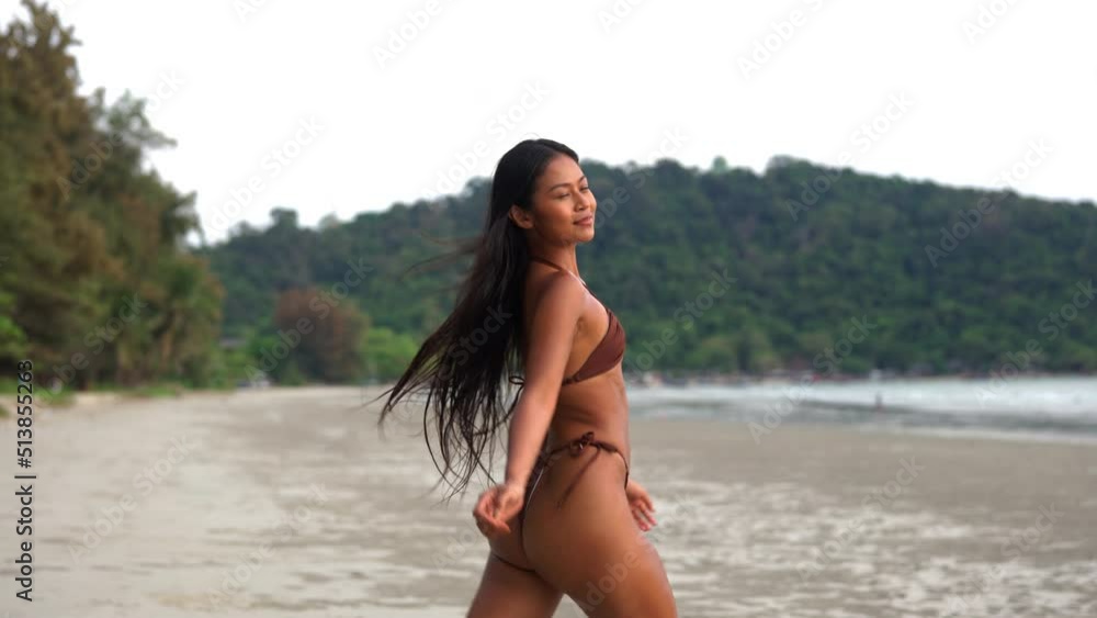 Beautiful Young Woman Walking Along Beach In Bikini Beautiful Young Woman Walking Along Beach In Bikini