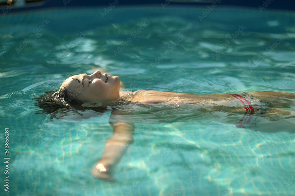 A boy swims in the pool in the summer heat