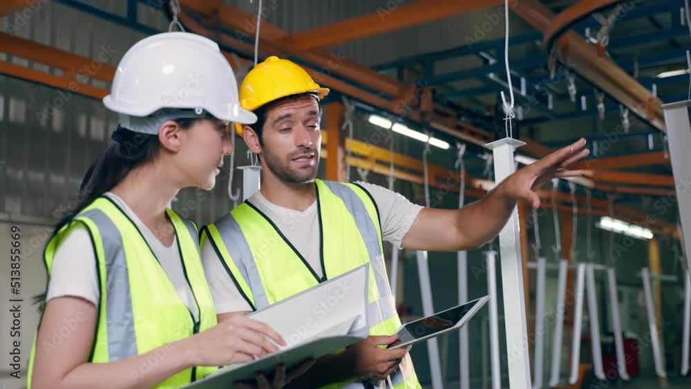 Caucasian male and Asian female industrial worker working in warehouse Caucasian male and Asian female industrial worker working in warehouse