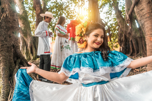 Latin young woman smiling and looking at camera wearing traditional Nicaraguan dress in a forested area