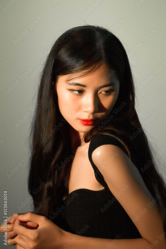 Fototapeta premium Fashion and beauty concept, Fashion woman with glowing makeup and pose on gray background