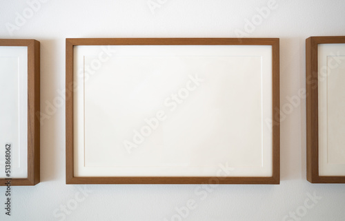 Wooden photo frames on white wall © wachiwit