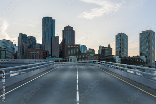 Empty urban asphalt road exterior with city buildings background. New modern highway concrete construction. Concept of way to success. Transportation logistic industry fast delivery. Boston. USA.