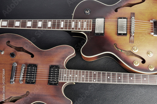 Two jazz electric guitars on a dark background. Close up.