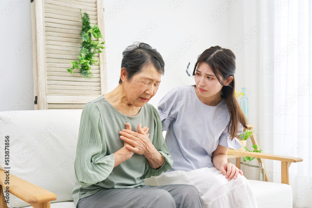 リビングで胸が苦しい高齢者女性 リビングで胸が苦しい高齢者女性