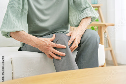 自宅で膝が痛いの高齢者女性のクローズアップ