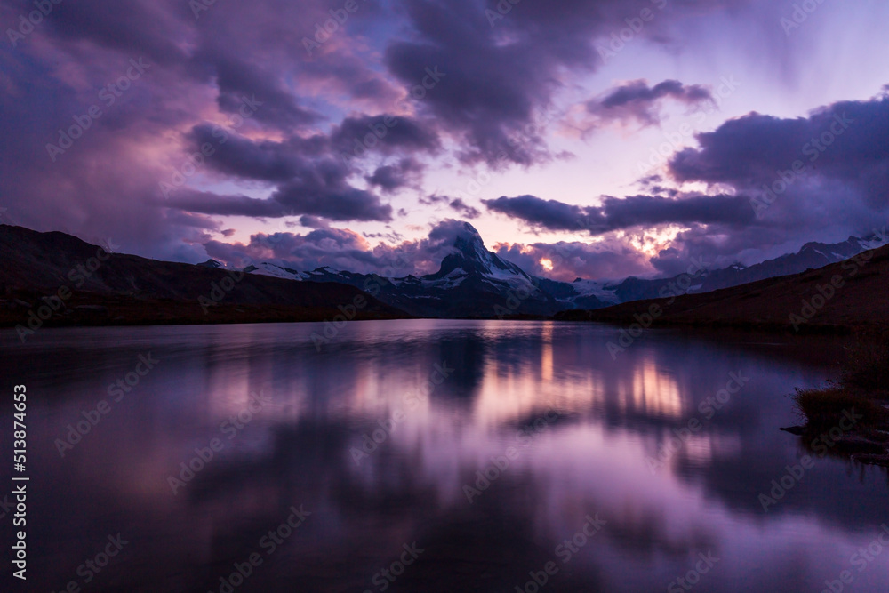 Beautiful sunset colors and cloudscape in the Swiss Alps in summer, with Matterhorn reflection in a lake
