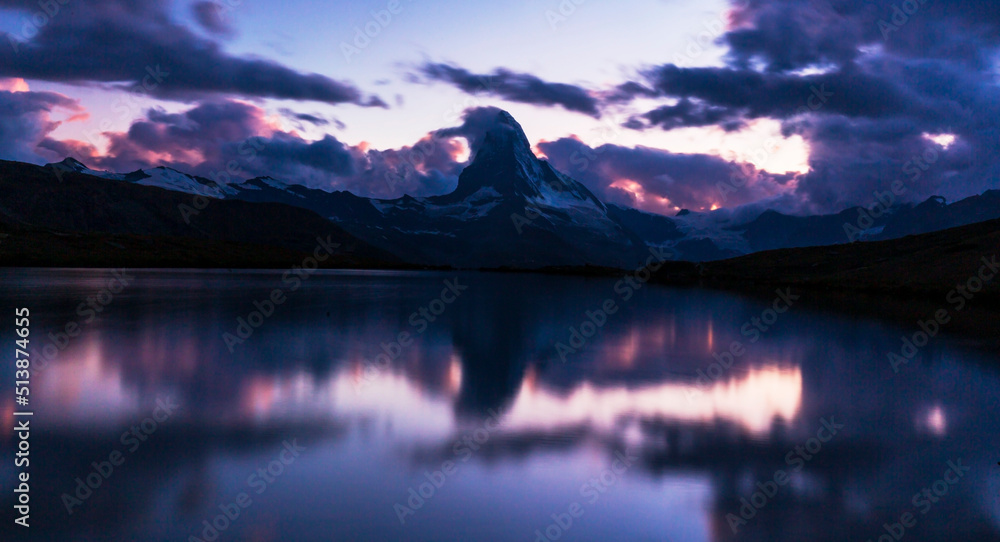 Beautiful sunset colors and cloudscape in the Swiss Alps in summer, with Matterhorn reflection in a lake