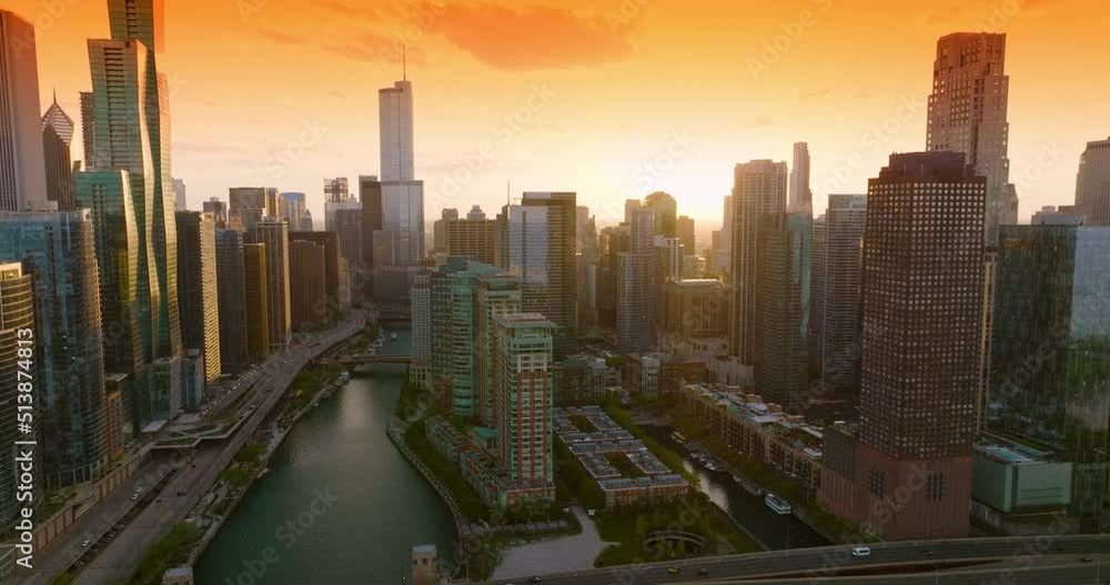 Terrific architecture of modern Chicago in the golden light of sundown. Sight of Chicago River among the beautiful buildings at the backdrop of orange sky. Terrific architecture of modern Chicago in the golden light of sundown. Sight of Chicago River among the beautiful buildings at the backdrop of orange sky.