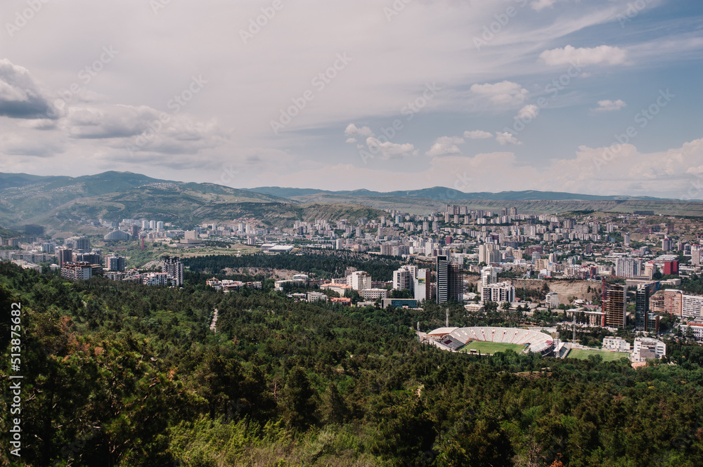 View of the city of Tbilisi in the capital of Georgia. All main landmarks on one shot: church, new and old houses, tower, city, town, mountains, park, stadium and streets.