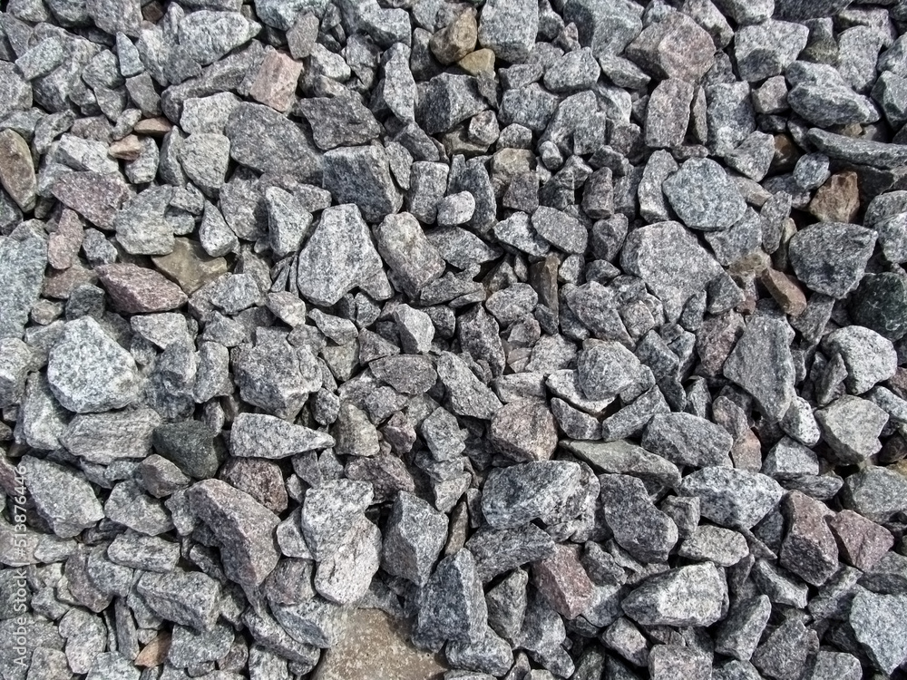 The backdrop of the gray gravel cobblestones. Crushed stone close-up evenly scattered over the surface - top view