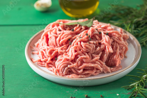 Raw Mince, minced Ground beef meat on a cutting board. Green background. Top view