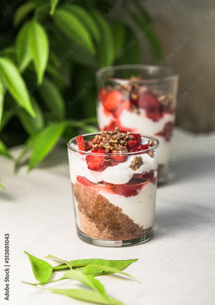 Breakfast layered parfait dessert with yogurt, sponge biscuit and fresh strawberry, white background copy space Breakfast layered parfait dessert with yogurt, sponge biscuit and fresh strawberry, white background copy space