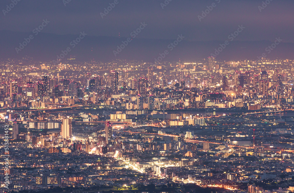 Obraz premium Lights from skyscrapers and office buildings in downtown Osaka at night