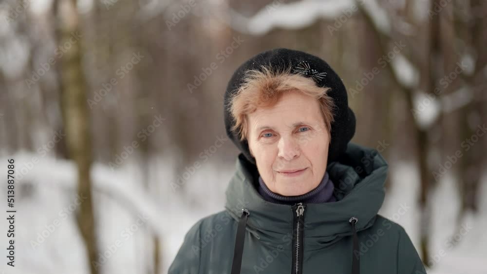 portrait of an elderly woman in a dark beret against a background of snow-covered trees portrait of an elderly woman in a dark beret against a background of snow-covered trees