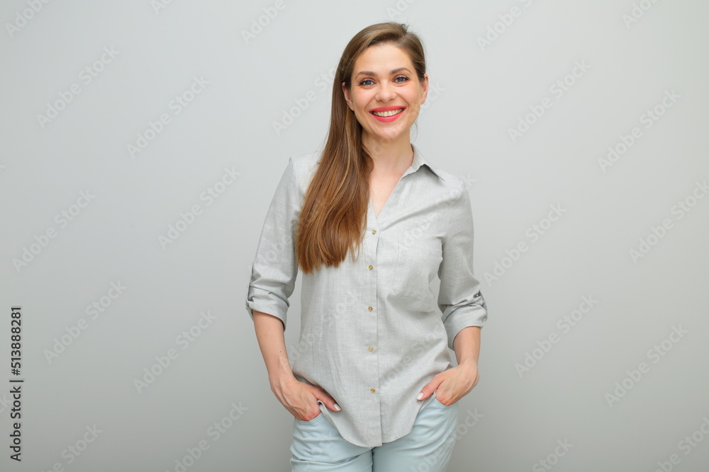 Smiling woman standing with hands in pockets, isolated female portrait, young lady dressed pants and gray shirt. Smiling woman standing with hands in pockets, isolated female portrait, young lady dressed pants and gray shirt.
