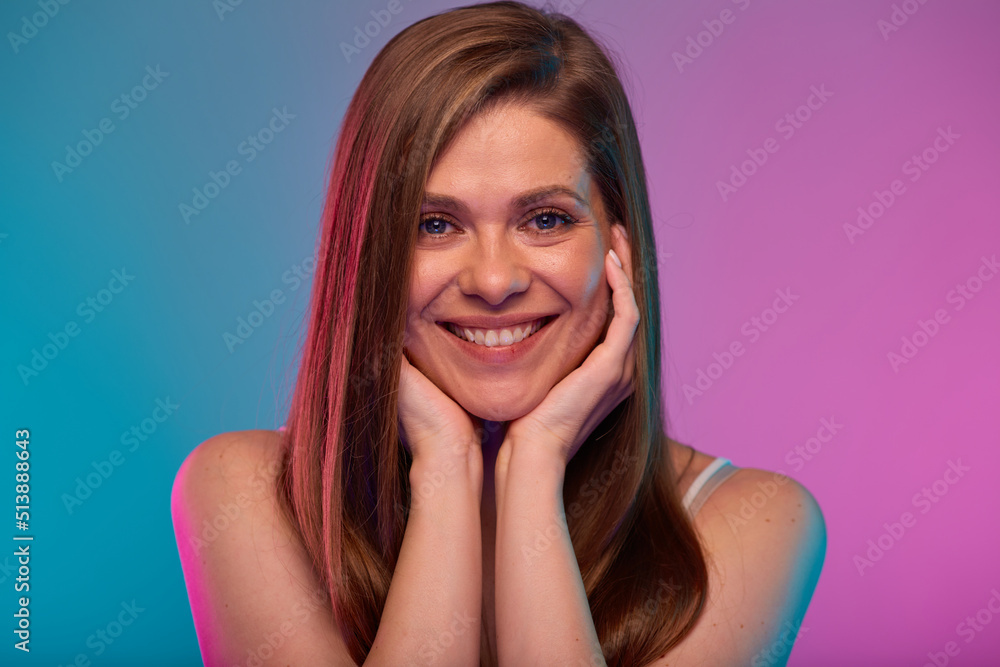 Smilng happy woman leaned face on her hands, portrait with neon lights colors effect. Girl isolated on neon background Smilng happy woman leaned face on her hands, portrait with neon lights colors effect. Girl isolated on neon background