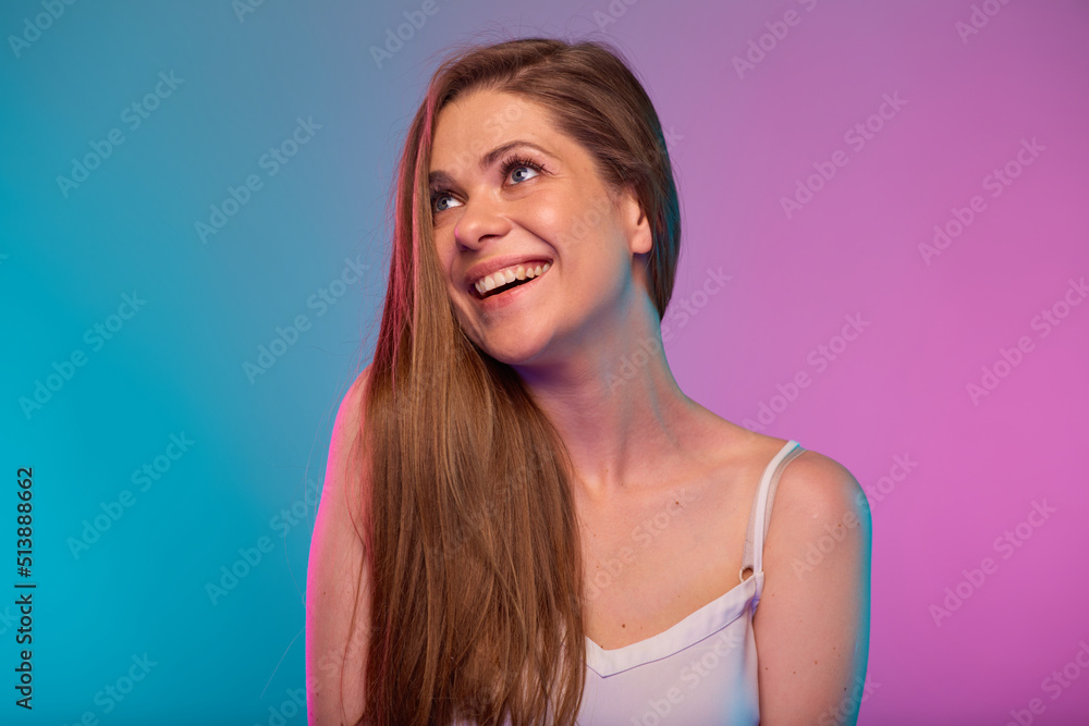 Smiling woman looking up face portrait with neon lights colors effect. Girl isolated on neon background. Smiling woman looking up face portrait with neon lights colors effect. Girl isolated on neon background.