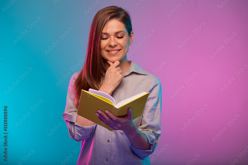 Teacher or student woman reading book, portrait with neon lights colors effect. Female model isolated on neon background Teacher or student woman reading book, portrait with neon lights colors effect. Female model isolated on neon background