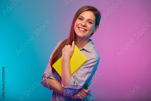 Teacher or student woman holding book, portrait with neon lights colors effect. Female model isolated on neon background