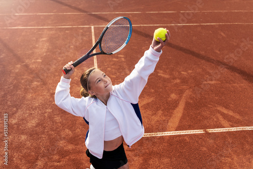 Pretty sports girl with racquet at the tennis court. Tennis player serving. Healthy lifestyle © Dulin