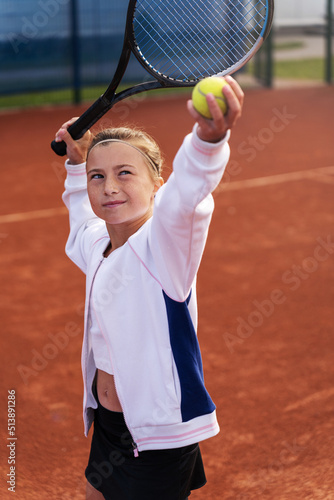 Close up of a little girl serving in tennis