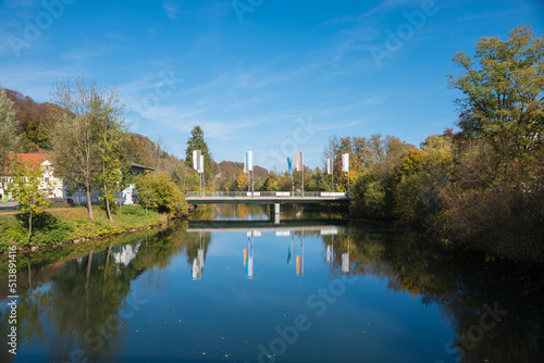 concrete bridge over Loisach river, with flagposts, reflecting in the water. bavarian landscape