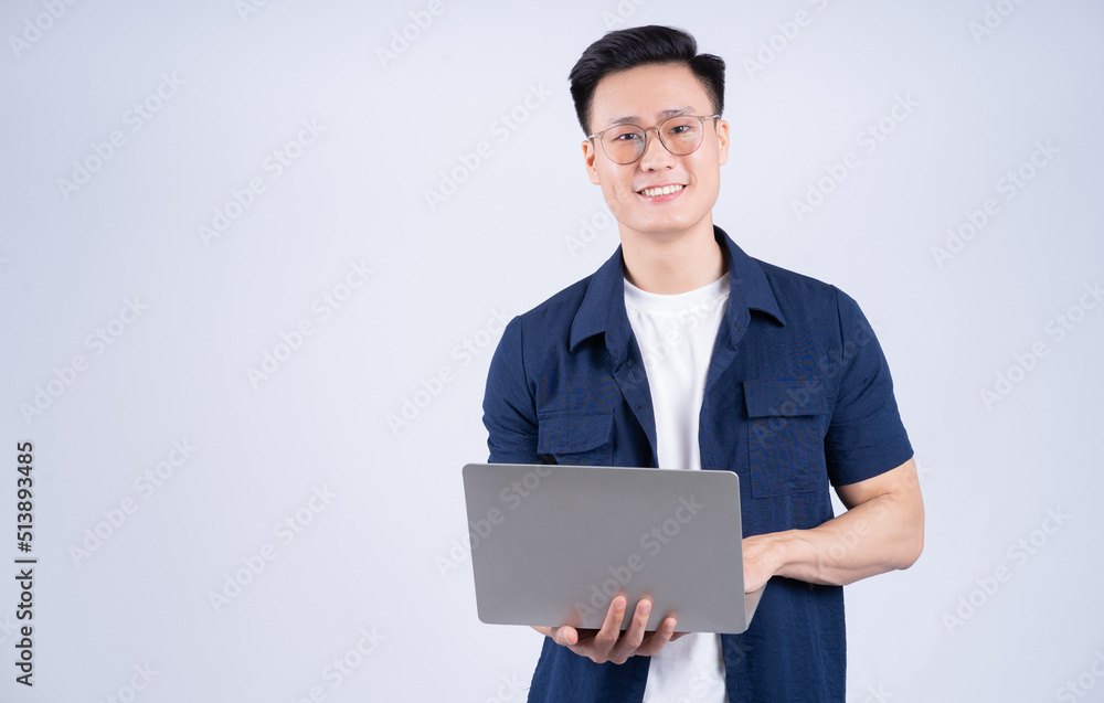 Young Asian man using laptop on white background Young Asian man using laptop on white background