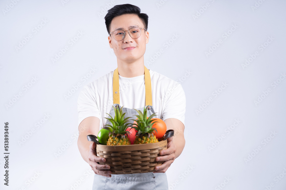 Image of young Asian waiter on background Image of young Asian waiter on background