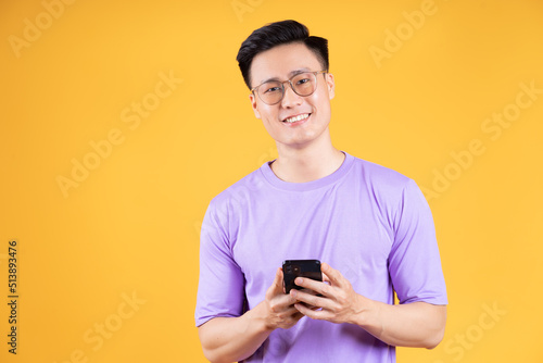 Image of young Asian man using smartphone on background