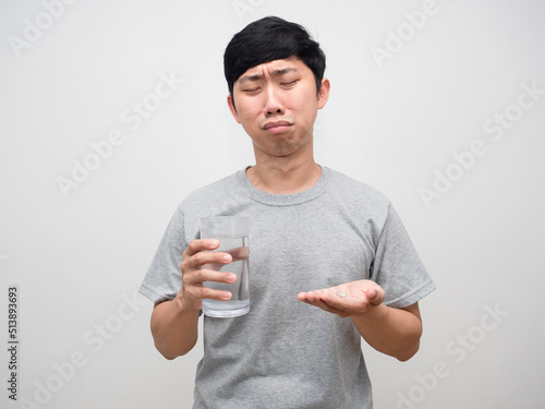 Sickness man feels bored to taking medicine,Asian man holding water glass with medicine