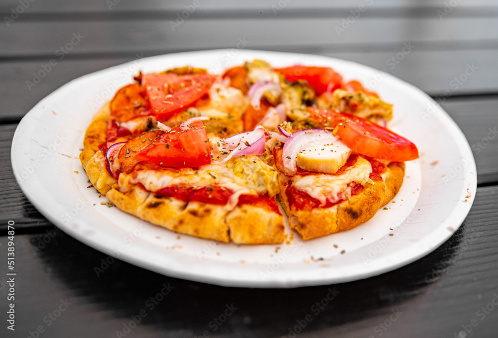 mini pita pizza with Mozzarella cheese, ham, mushrooms, salami. Italian pizza on wooden table background outdoor