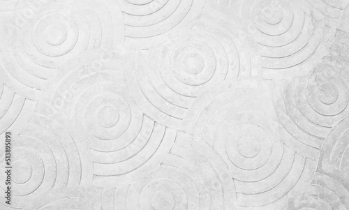 Abstract white paint floor stamped concrete surface on walkway in garden. Wallpaper pattern curved circle cement.