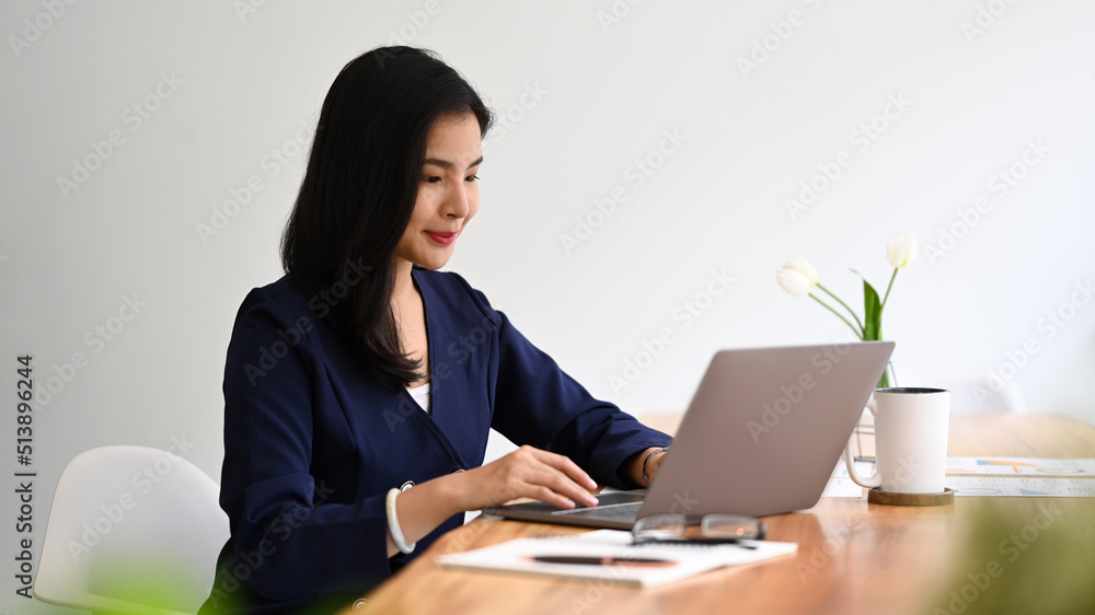 Creative female working with laptop computer, sitting at comfortable office Creative female working with laptop computer, sitting at comfortable office