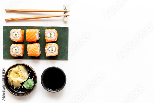 Japanese cuisine. Salmon sushi rolls on eco green papper plate