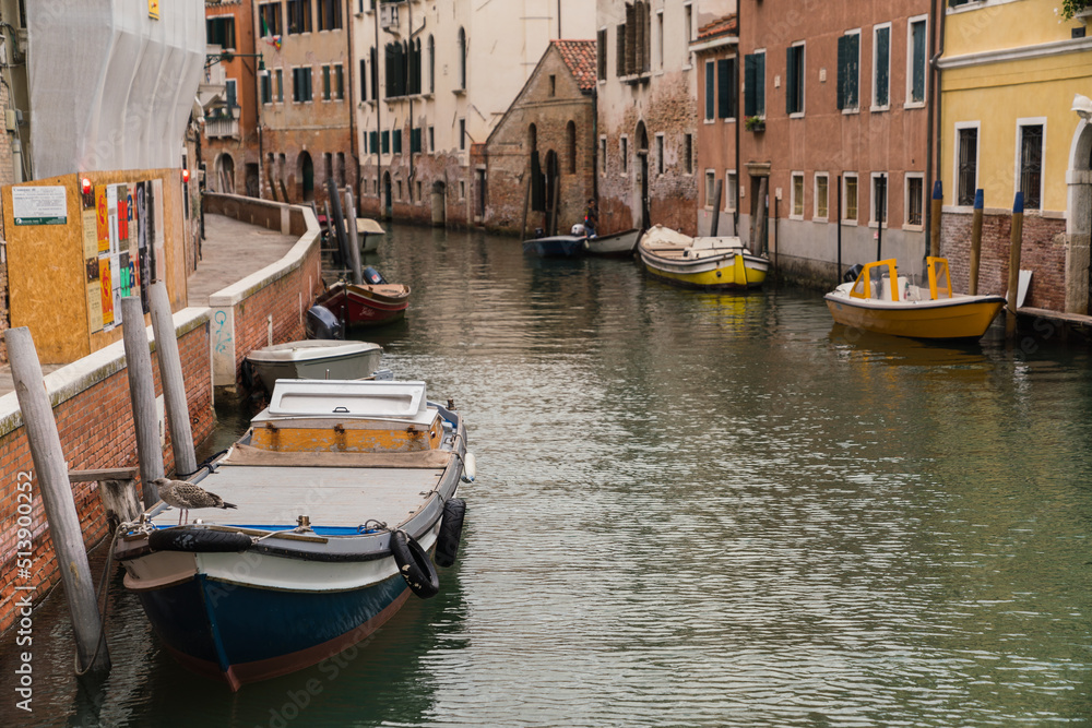 boats docked on canal in Venice, Italy and colorful buildings 