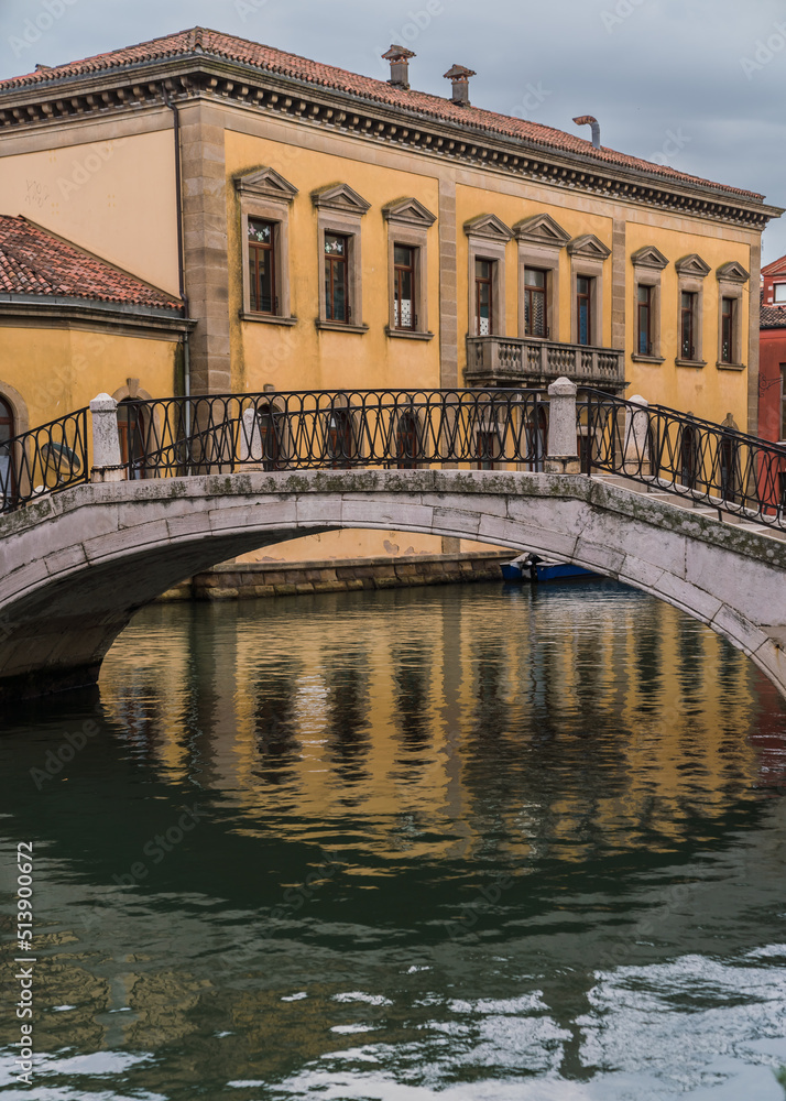 Yellow Venetian facade and bridge over a canal in Venice, Italy 