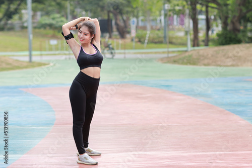 Athletic young healthy and beauty asian woman in sportswear standing and stretching outdoor for morning exercise. Active girl work out on biceps practice. Sport and lifestyle concept