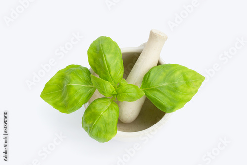 Basil leaves in mortar on white background.