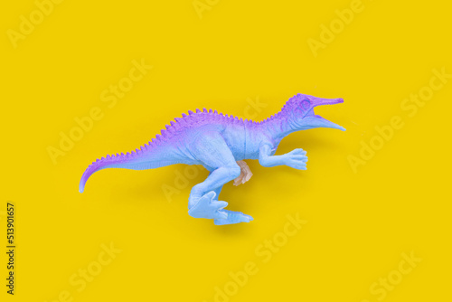 Plastic dinosaur toys on yellow background.