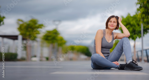 outdoor sports, workout and wellness concept. asian young strong, confident woman in sportive clothes Relaxing After Fitness Workout In Park. Female runner taking break from running sport. © YURII Seleznov