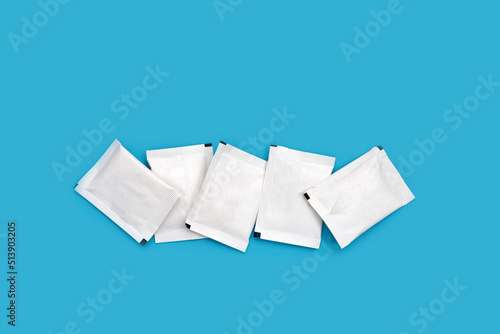 Foto Sugar sachets on blue background.