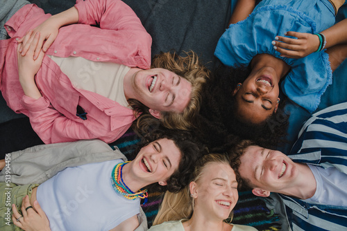 Top view of diverse group of friends having fun together at park lauging and lying on ground, Friendship and lifestyle concepts photo