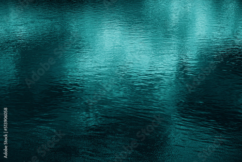 Obraz na płótnie Blue green water surface. Night. Small waves. Ripples. Reflection of light. Dark teal water background with space for design. w salonie