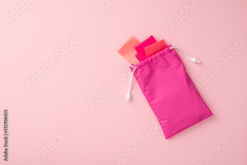 Sports concept. Top view photo of pink resistance bands in special bag on isolated pastel pink background with copyspace