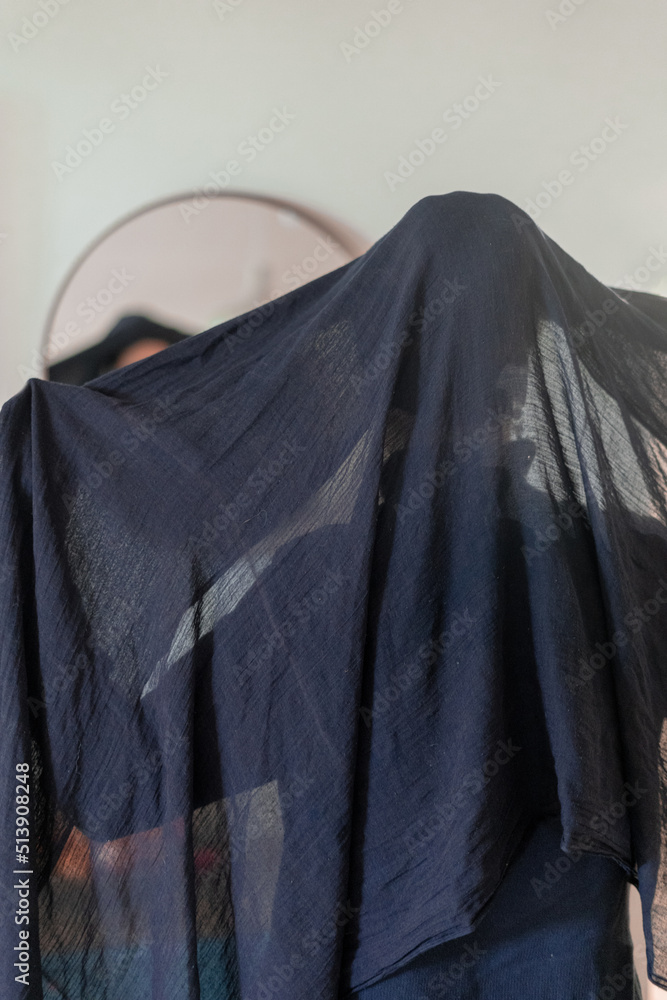 Young woman covers her head with a large dark shawl (16)
