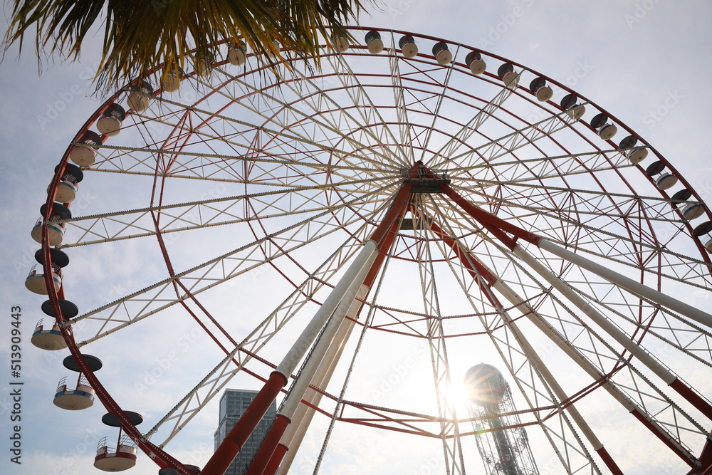 BATUMI, GEORGIA - MAY 31, 2022: Beautiful Ferris wheel outdoors, low angle view BATUMI, GEORGIA - MAY 31, 2022: Beautiful Ferris wheel outdoors, low angle view